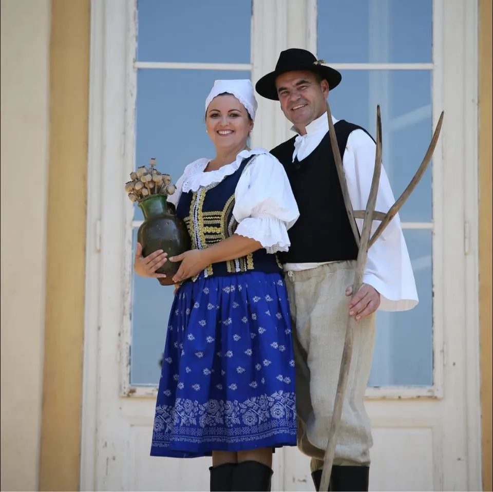 Silvia a Jozef v slovenských krojoch — Silvia s krčahom makovíc, Jozef s vidlami