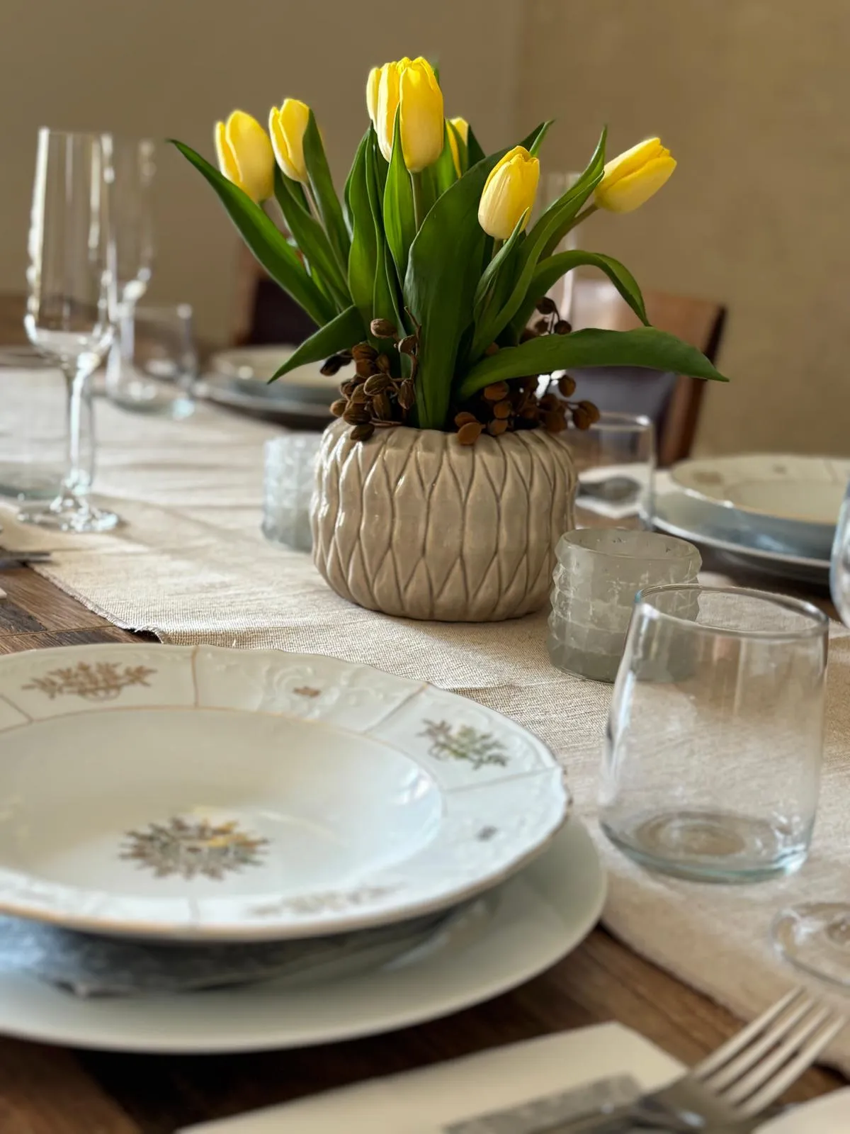 Slávnostne prestretý stôl so žltými tulipánmi, porcelánom a pohármi